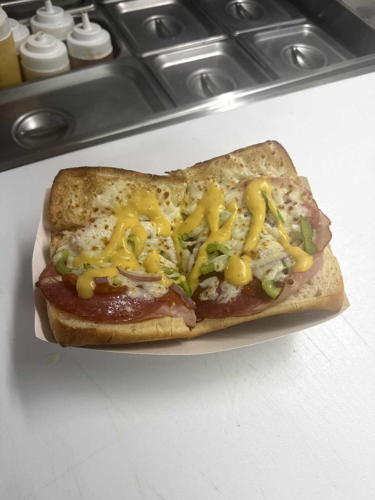 The Late Rabbit hot Italian sandwich with melted mozzarella and mustard drizzle at The Mad Hatter Saloon in Cascade, CO