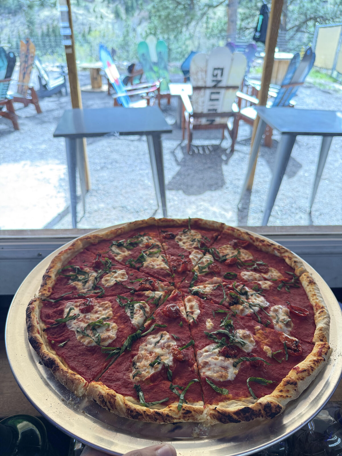 Wood-fired pizza with fresh mozzarella, cherry tomatoes, and basil at The Mad Hatter Saloon in Cascade, CO