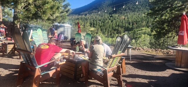 Guests eating and drinking on the outdoor patio at The Mad Hatter Saloon near Pikes Peak in Cascade, CO