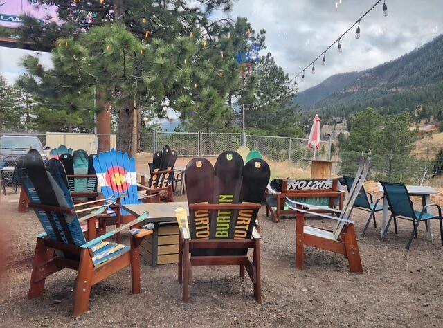 Outdoor patio seating made from snowboard chairs with a view of Pikes Peak at The Mad Hatter Saloon